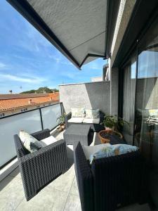 a balcony with chairs and tables on a roof at Appartement Casa Buisan in Argelès-sur-Mer