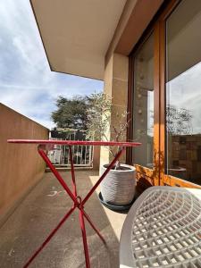 une table en métal sur un balcon avec une fenêtre dans l'établissement Jeux Olympique au Cœur de Paris, à Saint-Cloud