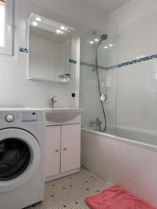 ein Badezimmer mit einer Waschmaschine und einem Waschbecken in der Unterkunft Jeux Olympique au Cœur de Paris in Saint-Cloud