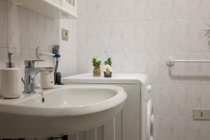 a white bathroom with a sink and a toilet at Patty14 By Case al Lago in Sirmione