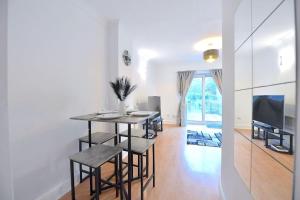 a dining room with a table and a television at Charsley Lodge in London