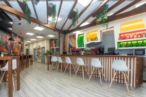 a restaurant with a bar with white stools at Albergue Llanes Hostel in Llanes