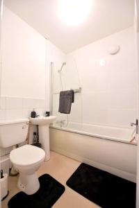 a white bathroom with a toilet and a sink at Charsley Lodge in London