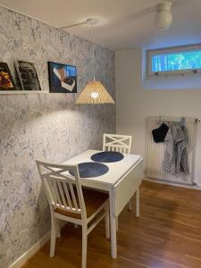 a dining room with a white table and a chair at Limhamn city-ocean in Limhamn