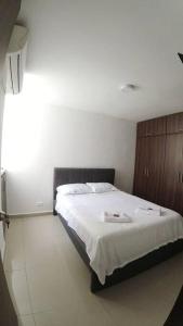 ein Schlafzimmer mit einem großen Bett mit weißer Bettwäsche in der Unterkunft Cómodo Apartamento Amoblado en Condominio in Cúcuta