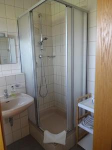 uma casa de banho com um chuveiro e um lavatório. em Gästehaus Regina em Bad Füssing
