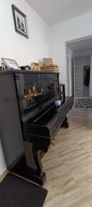 a black piano sitting in a living room at Piano Apartament in Gura Humorului