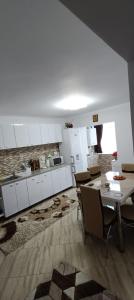 a kitchen with white cabinets and a table and chairs at Piano Apartament in Gura Humorului