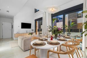 uma sala de estar com uma mesa branca e cadeiras em Luxury Villa with Private Swimming Pool in Cabo Roig em Playas de Orihuela