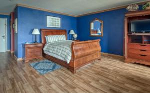 a bedroom with a bed and a blue wall at Captains Quarters - Anchor Pier Lodge in Newport