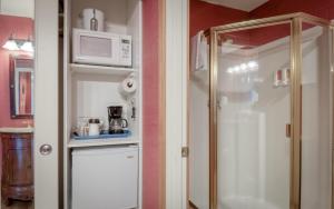 a small kitchen with a microwave and a refrigerator at Captains Quarters - Anchor Pier Lodge in Newport