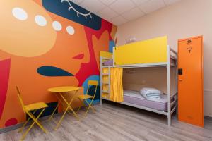 - une chambre pour enfants avec des lits superposés et une table dans l'établissement Albergue Hostel Llanes, à Llanes