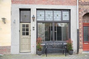 a bench in front of a building with a door at Appartement aan de Geul in Valkenburg
