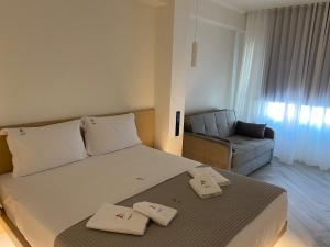 a bedroom with a large bed and a couch at Triple A - Stylish Seven On The Pedestrian - FREE Parking! in Athens
