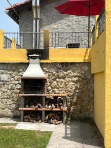 a brick building with a vase and an umbrella at Casa BellaTerra in Villasana de Mena