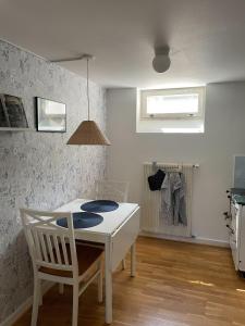 une salle à manger avec une table blanche et une chaise dans l'établissement Limhamn city-ocean, à Limhamn