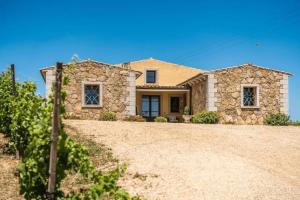 a large stone house with a gravel driveway at Locanda in Vigna in Arzachena