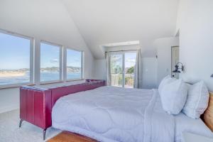 a white bedroom with a large bed and large windows at Walters Waldport in Waldport
