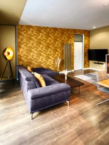 Exklusives Leipzig City Apartment Sunrise في لايبزيغ: غرفة معيشة مع أريكة زرقاء وطاولة