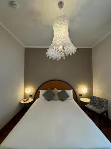 Un dormitorio con una cama grande y una lámpara de araña. en Delle Nazioni Milan Hotel en Milán