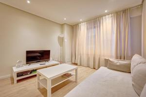 a living room with a couch and a tv and a table at La paz home by Clabao in Logroño