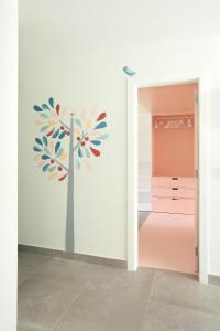 a hallway with a tree mural on the wall at A Casa da Porta Azul in Porches +17 photos