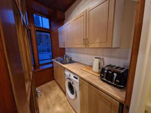 a kitchen with a sink and a washing machine at The Old Post Office House in Perth