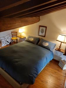 a bedroom with a large bed with blue sheets at Casa di Corte in Scansano