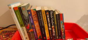 a pile of books sitting on top of a shelf at Kuttickattil Gardens Homestay in Kottayam