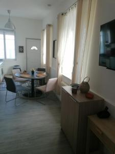 salon ze stołem, krzesłami i telewizorem w obiekcie L'orientale w mieście Rouvroy