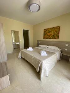 a bedroom with a bed with two towels on it at Historico Loft & Rooms Palazzo Adragna XIX in Trapani