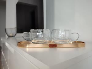 two glass mugs on a wooden tray on a counter at Summer day Chernomorets in Chernomorets