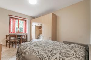 um quarto com uma cama e uma mesa em Appartamento Pallin - Affitti Brevi Italia em Aosta