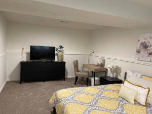 a bedroom with a bed and a tv and a desk at Escape to Tranquility in our Spacious 4-Bedroom Retreat in Charlotte