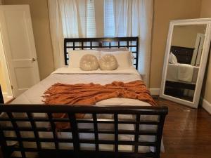 ein Schlafzimmer mit einem Bett mit zwei Kissen und einem Spiegel in der Unterkunft Historic Charmer, Pet-friendly in Concord