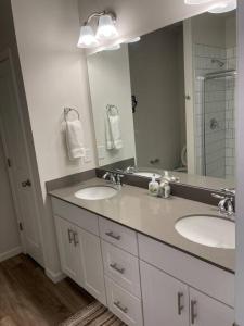 a bathroom with two sinks and a large mirror at Embrace the Harmony of Nature and Urban Living in Concord +15 photos