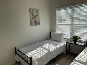 a small bedroom with a bed and a window at Embrace the Harmony of Nature and Urban Living in Concord