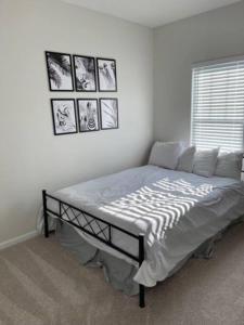 a bed in a bedroom with pictures on the wall at Embrace the Harmony of Nature and Urban Living in Concord