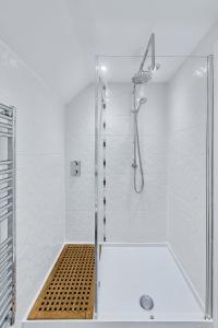 a white bathroom with a shower with a glass door at Kinkell House Rooms in Cononbridge +27 photos