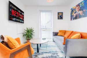 uma sala de estar com um sofá e uma mesa em Birmingham City Centre Stylish 2 Bed House ☆ FREE PARKING → With 55 Inch Smart TV, FREE NETFLIX & WIFI ✘ Comfy Seating Area - By O2 Academy, Bullring, Newstreet, Chinatown, Cube & Mailbox em Birmingham