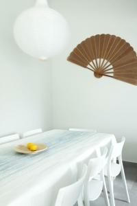 ein weißes Zimmer mit einem Tisch und zwei Sonnenschirmen darauf in der Unterkunft A Casa da Porta Azul in Porches