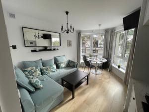 un salon avec un canapé bleu et une table dans l'établissement Hilltom Dunes, à Rowy