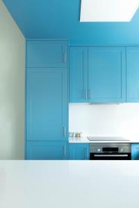 uma cozinha com armários azuis e um fogão em A Casa da Porta Azul em Porches