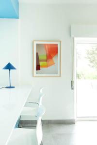 a white room with a glass table and a picture at A Casa da Porta Azul in Porches