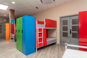 a room with colorful bunk beds and a refrigerator at Albergue Hostel Llanes in Llanes