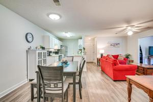 a living room with a table and a red couch at Murrells Inlet Condo with Pool Access, Near Beach! in Myrtle Beach