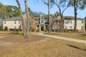 a large house with trees in front of it at Murrells Inlet Condo with Pool Access, Near Beach! in Myrtle Beach