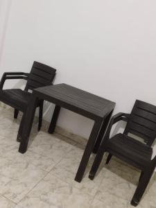 特里溫福港的住宿－APARTAMENTO PUERTO TRIUNFO ANTIOQUIA，两张黑椅子、一张木桌和一张长凳
