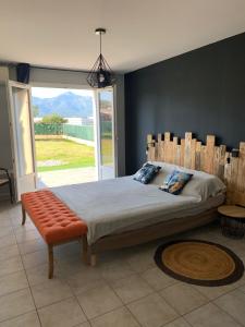 sypialnia z dużym łóżkiem i dużym oknem w obiekcie Villa T3 5p de 85m² avec jardin à CALVI w Calvi