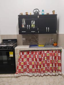 特里溫福港的住宿－APARTAMENTO PUERTO TRIUNFO ANTIOQUIA，厨房配有带红色和白色桌布的台面
